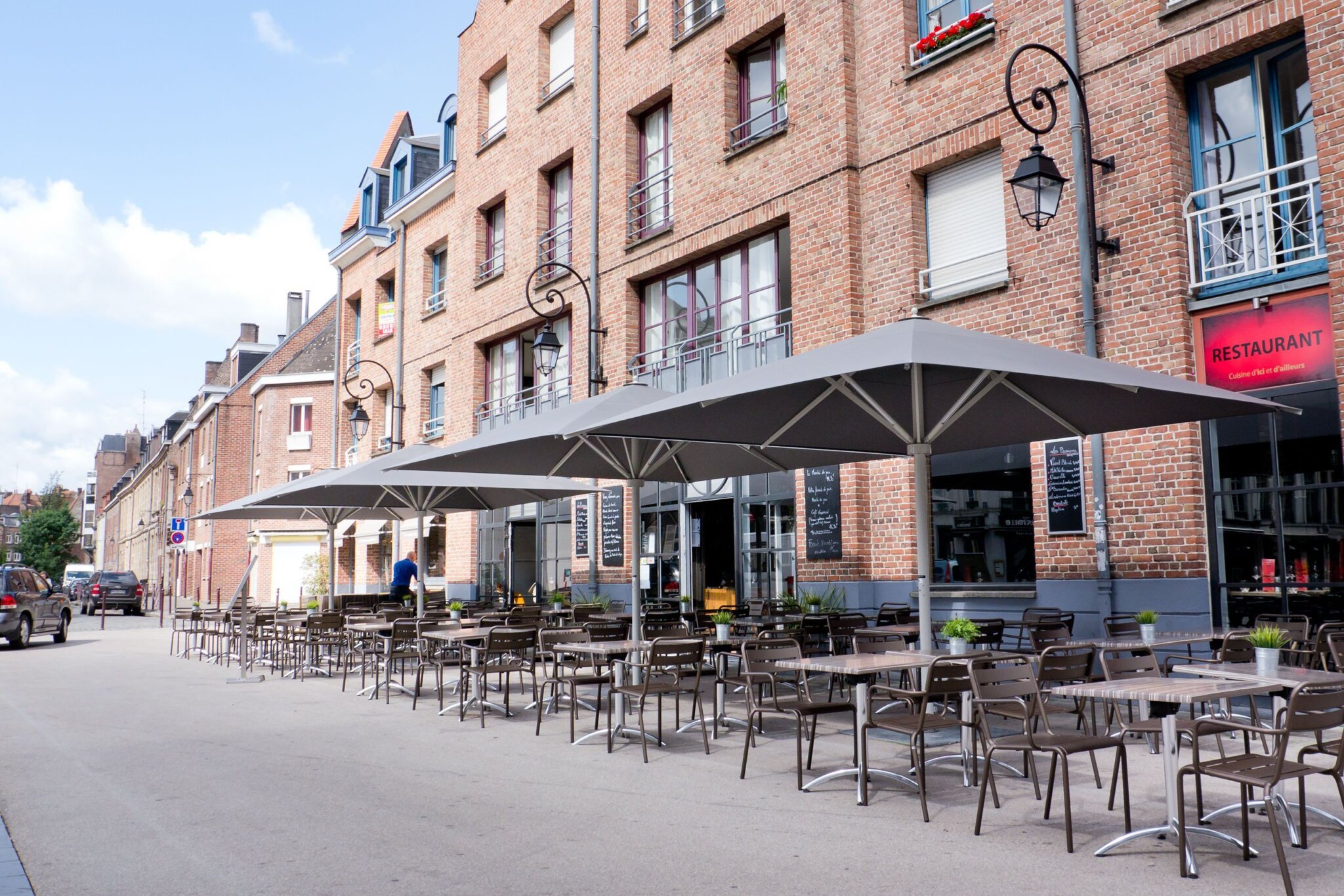 Abendliche Terrasse mit beleuchtetem rotem Sonnenschirm Graue Sonnenschirme für den Außenbereich der Gastronomie