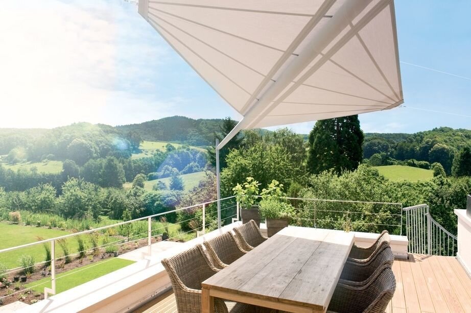 Automatische Terrassenbeschattung mit Fernbedienung Zwei weiße Sonnensegel über dem Esstisch einer Terrasse