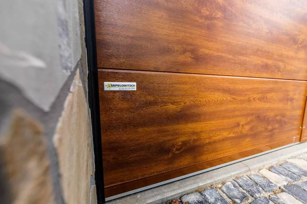 Markise als Sonnenschutz Braunes Garagentor in Holzoptik