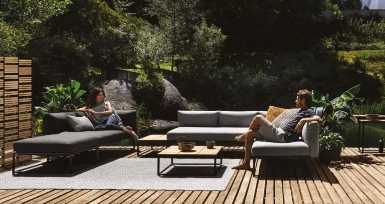 Abendliche Terrasse mit beleuchtetem rotem Sonnenschirm Sitzecke mit grauen Sitzpolstern