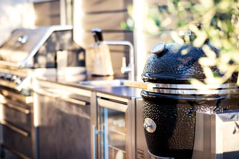 Abendliche Terrasse mit beleuchtetem rotem Sonnenschirm Silberne outdoor Küche von BURNOUT
