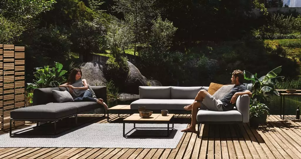 Abendliche Terrasse mit beleuchtetem rotem Sonnenschirm Graue Outdoor Sofas