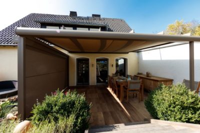 Terrassenüberdachung mit Sonnenschutz-Erweiterung sorgt für Schatten auf der Terrasse