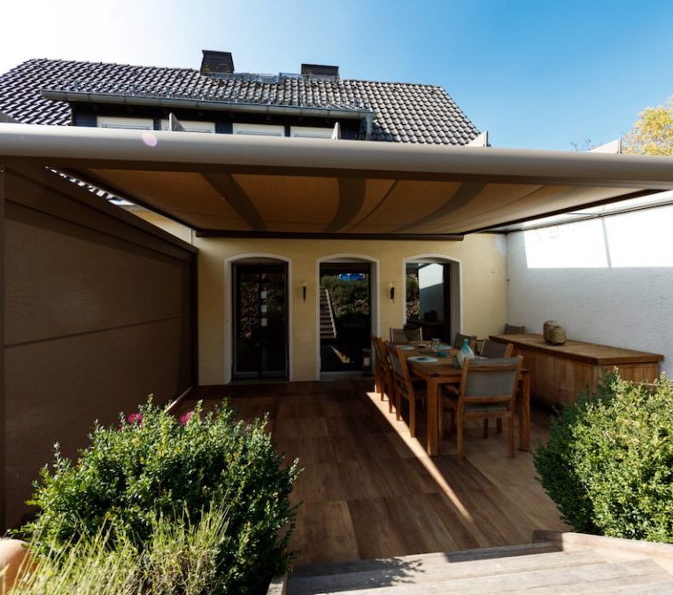 Terrassenüberdachung mit Sonnenschutz-Erweiterung sorgt für Schatten auf der Terrasse