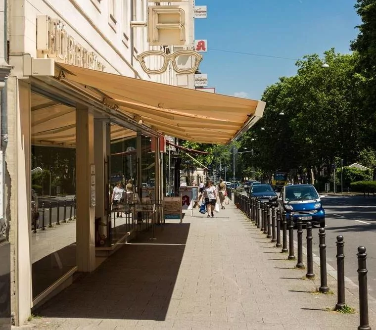 Markise schützt das Schaufenster einer Optiker-Filiale